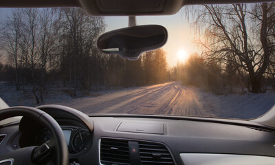 Canvas Print - View from the car on snowy winter road in the forest