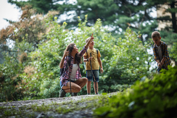 Wall Mural - mother and her little sons hiking trough forest .they learning about animal and plant life.