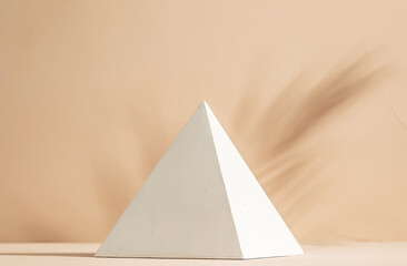 Gypsum pyramid in sunlight and palm leaf shadow on clay wall background