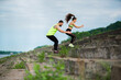 © Georgii - Strong fit couple in sportswear exercising outdoor. Healthy pair training jumping on stairs. Workout workshop in urban
