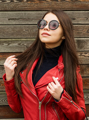 Wall Mural - Beautiful brunette woman in sunglasses over wooden background. Street fashion. Outdoors.