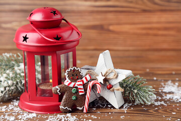 Canvas Print - Red candlestick with gingerbread cookie, star and fir tree branches on brown wooden background