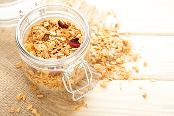 Poster - Tasty granola in glass jar on brown wooden background