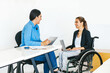 © Marcos - Two young latin female working in office and one woman in wheelchair in Mexico City