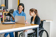 © Marcos - Hispanic woman in wheelchair with her colleagues at workplace in Mexico City