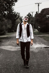 Halloween make up mask. Young man in joker mask.