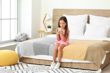 Cute Little Girl With Mobile Phone In Bedroom