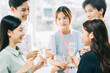 © Timeimage - Group Asian business people are having a toast together and chatting at a company party