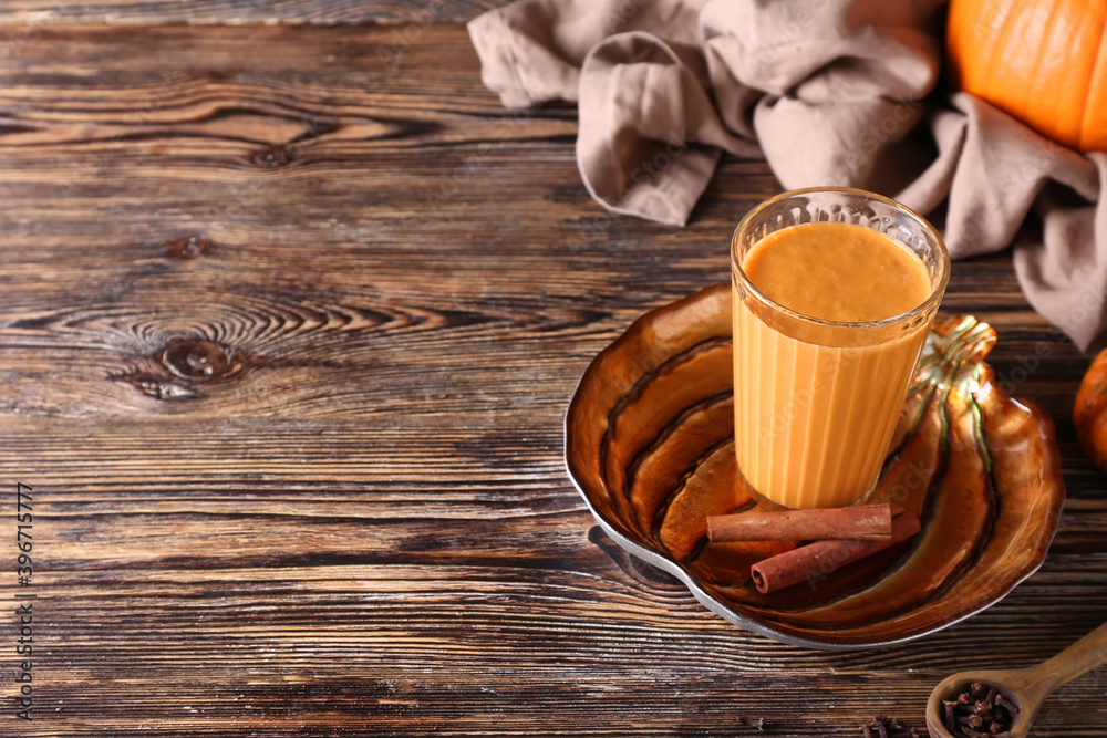 Glass of tasty pumpkin smoothie on table