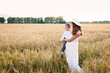 © natalialeb - Caucasian beautiful mother hugs her child son in the summer wheat field at sunset, summer and harvest, natural products and relaxation in the countryside, motherhood