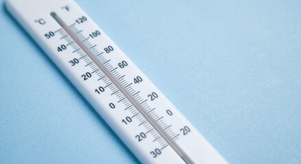 White thermometer on blue background.