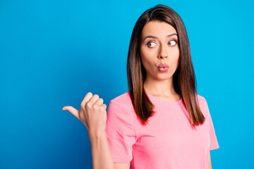 Wall Mural - Photo portrait of pretty brunette showing with finger at empty space whistling isolated on vibrant blue color background