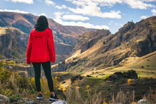 Female Tourist Stands On The Rock And Admires Dramatic Landscape Of Rocky Area In Vardzia With Tmogvi Fortress On Top Hill. Solotravel Adventure Woman.