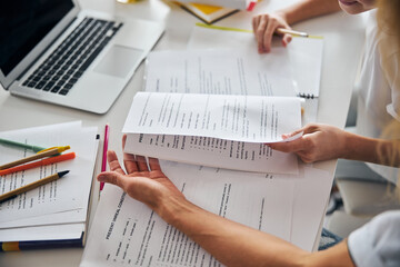 Young person revising the learning materials with her mother