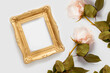 Gold photo frame with copy space decorated with roses. The concept of beautiful backgrounds for text.