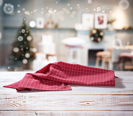 Red napkin on wooden table and Christmas background.