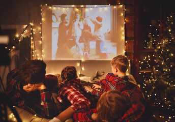 Wall Mural - family mother father and children watching projector, TV, movies with popcorn in   christmas evening   at home.