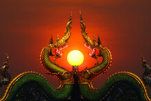 Two Naga Status And Pole In Middle And Sunset Red Sky On Top Of Pole Clear Evening Cloud