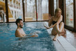 © BGStock72 - Young couple relaxing on the poolside of interior swimming pool