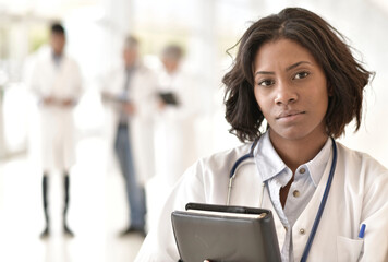 Wall Mural - Portrait of young female doctor standing in hospital corridor