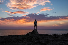 Man With His Back On A Rock, Watching The Sunset Over The Sea
