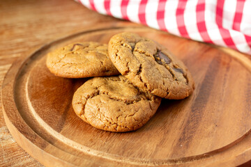 Wall Mural - Delicious Homemade Chocolate Chip Cookies. Homemade chocolate cookies on wooden table background. cookies with dark chocolate chips on wooden plate. Fresh homemade cookies in a wooden plate.