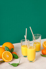 Wall Mural - Freshly squeezed orange juice in a glasses with straws and fresh fruits with leaves, healthy drink, vitamin c concept, front view, copy space for a text