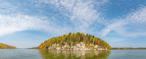Wall Mural - calm lake, river stone hill on the bank of the river, autumn colored coniferous trees on the other s