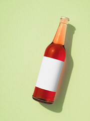 Leinwandbilder - One full transparent glass beer bottle laying on light green surface.