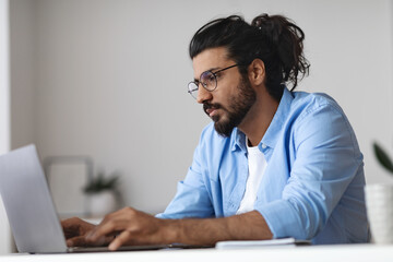 Aufkleber - Young Western Employee Working On Laptop At Desk In Office