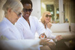 © Tom Merton/Caia Image - Senior women friends in spa bathrobes and sunglasses on patio