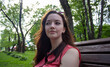 © Dzmitry - Beautiful smiling young girl sitting on a brown park bench.