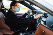 © Drobot Dean - Focused businesswoman in face mask using navigator while driving car