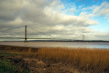 View of the Humber Bridge with a dramatic cloudy sky from the south bank of the Humber Estuary, North Lincolnshire, England