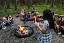 Girl Using Phone In Summer Camp With Campfire