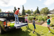 Family Loading Pickup Truck In Community Garden