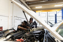Auto Mechanics Modifying SUV Engine In Garage