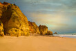 .beautiful ocean shore with clean yellow sand at sunset with a picturesque sky and cliff. summer in portugal in algarve