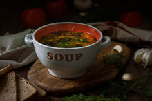 Appetizing Soup With Tomato And Black Olives In A Ceramic Bowl  On Vintage Wooden Board.