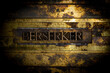 Berserker text formed by real authentic typeset letters on vintage textured grunge bronze background
