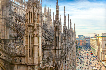 Roof of Milan Cathedral Duomo di Milano with Gothic spires and white marble statues. Top tourist attraction on piazza in Milan, Lombardia, Italy. Wide angle view of old Gothic architecture and art