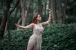 © Evgenia - Young beautiful woman dancing in the woods in a beige suit decorated with macrame. The concept of balance, natural cosmetics and health.