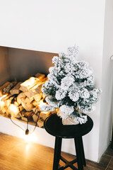 Canvas Print - Small Christmas tree in bright white living room on the table.