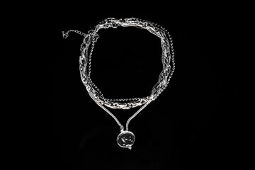 Silver jewelry chain with medallion isolated on black background