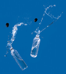 Poster - Water splash out of bottle on a blue background