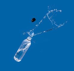 Poster - Water splash out of bottle on a blue background