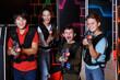 © JackF - excited happy teen boy and girl aiming laser gun at other players during lasertag game in dark room