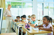 © JackF - Portrait of focused aframerican preteen schoolgirl writing exercises in workbook in classroom during lesson