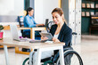 © Marcos - Young latin woman in wheelchair at workplace