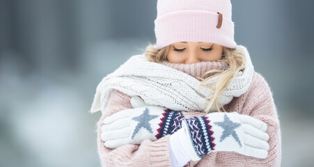 Freezing cold woman dressed in wooly clothes on a winter day, covered upto her nose